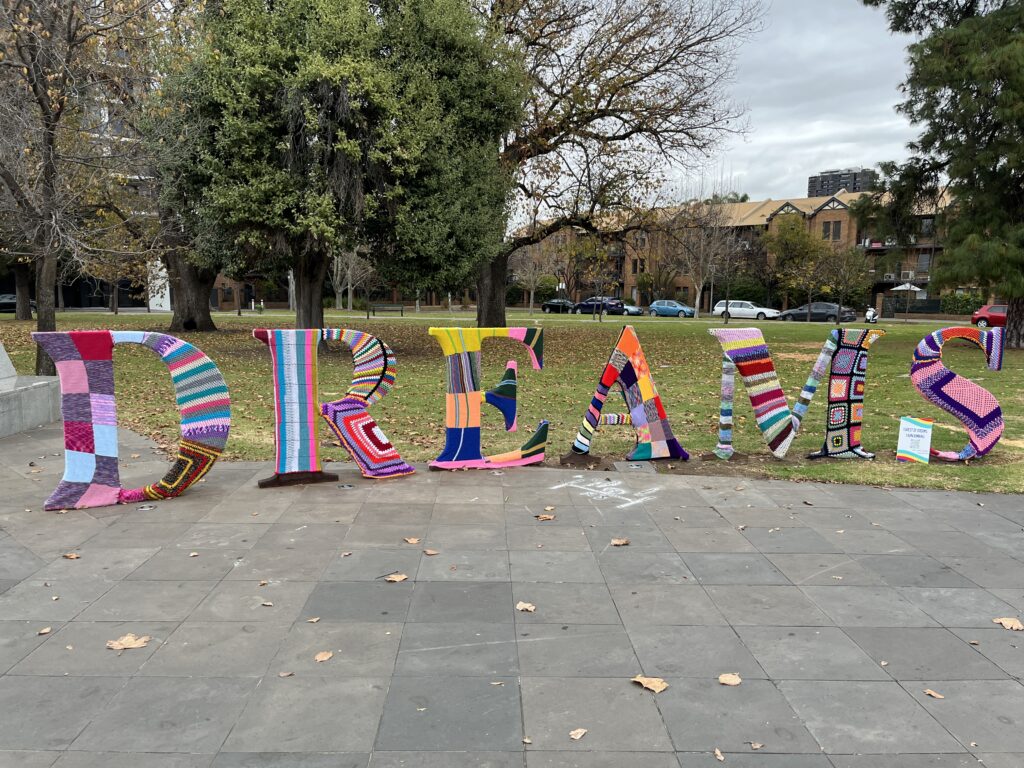Large letters about a metre high spell out the word "DREAMS" in a park. They have been covered in colourful knitting and crochet.